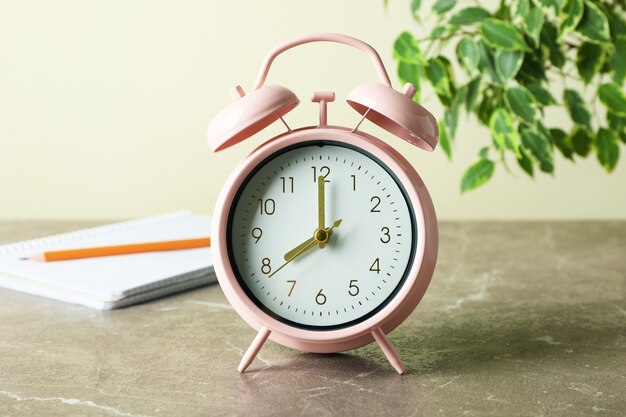 Education concept with alarm clock on gray table