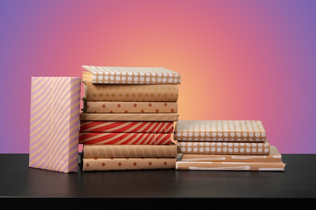 Education concept with stack of books on a table against colored background