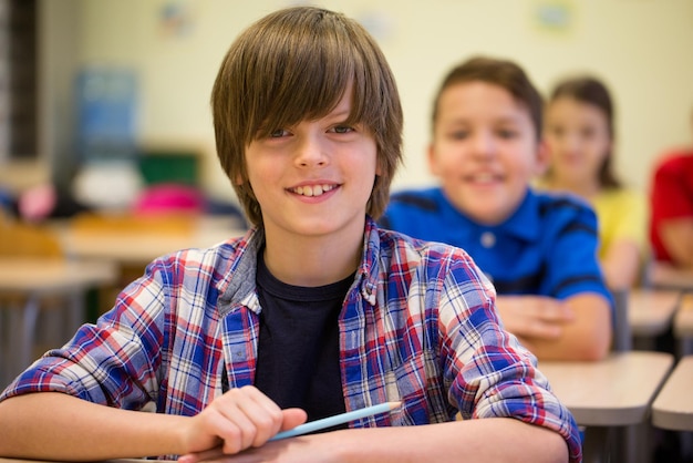 education, elementary school, learning and people concept - group of smiling school kids sitting in classroom