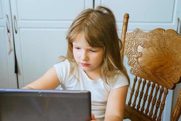 Фото Образование свободное время технологии и интернет-концепция маленькая студентка с планшетным пк дома
