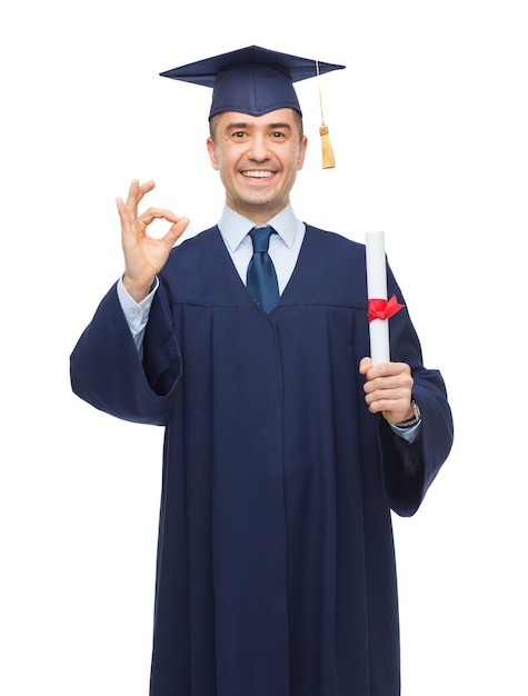 education, graduation, gesture and people concept - smiling adult student in mortarboard with diploma showing ok hand sign