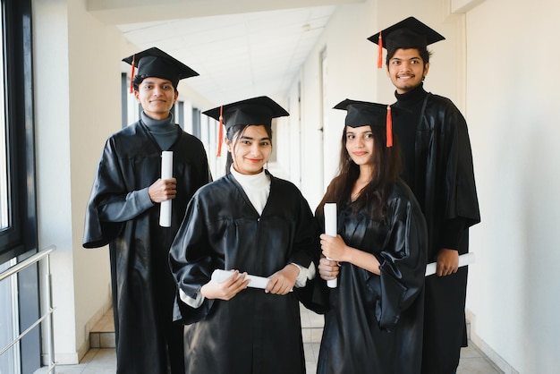 Education, graduation and people concept - group of happy indian students