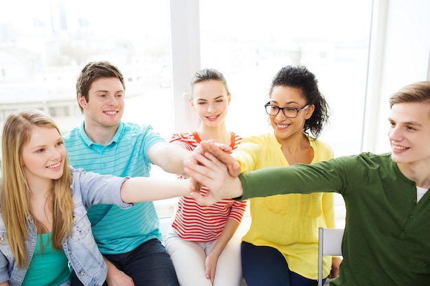 education and happiness concept - smiling students at school making high five gesture