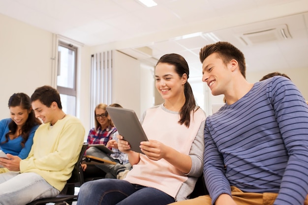 education, high school, teamwork and people concept - group of smiling students with tablet pc computers making photo or video in lecture hall