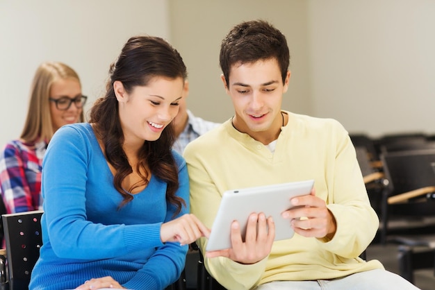 Concetto di istruzione, scuola superiore, lavoro di squadra e persone - gruppo di studenti sorridenti con computer tablet pc seduti in aula