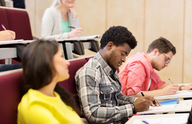 education, high school, university, learning and people concept - group of international students in lecture hall