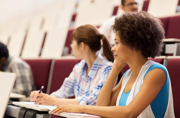 Photo education, high school, university, learning and people concept - group of international students talking in lecture hall