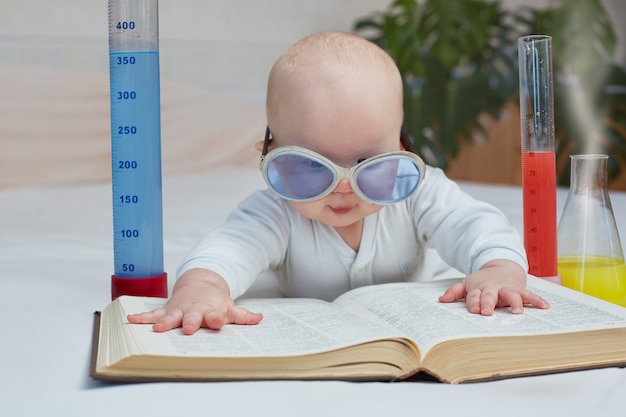 Istruzione e formazione domestica. cute baby legge un libro di medicina, scienza, esperimenti chimici. immagine orizzontale