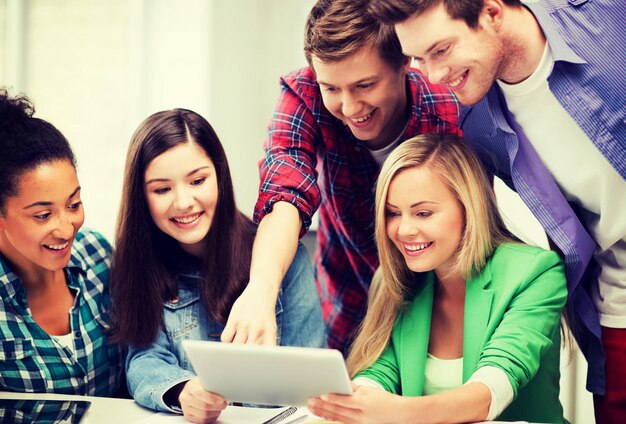 education and internet - smiling students looking at tablet pc in lecture at school