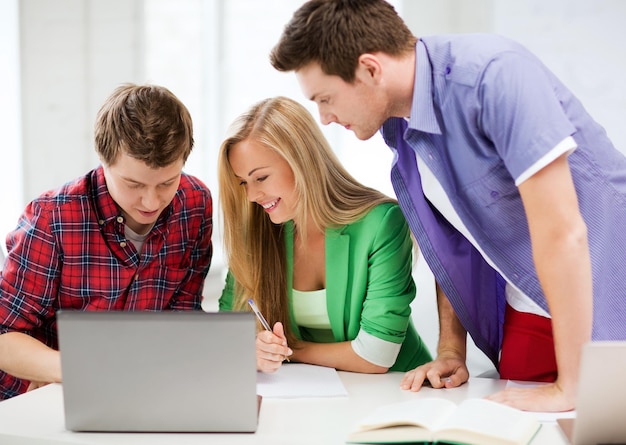 education and internet - smiling students writing test or exam in lecture at school