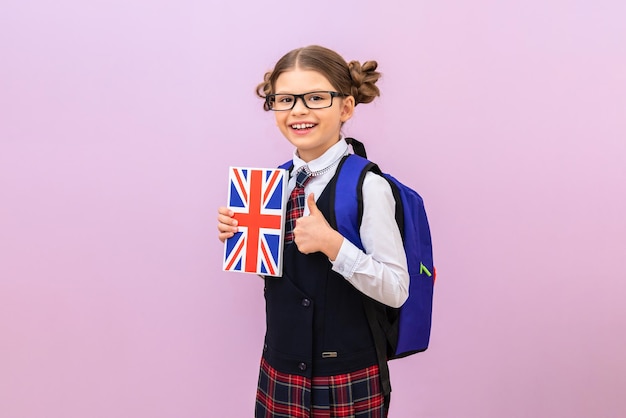 Education and knowledge. a teenage girl is ready to study. a schoolgirl with an English textbook and a backpack. a student with glasses goes to school. isolated background.