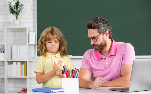 교육 및 학습 개념 아버지와 아들이 학교 교사와 어린 학생 포에서 숙제를 하고 있습니다.