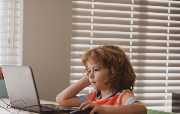 Photo education and learning for kids portrait of concentrated kid surfing the net in school