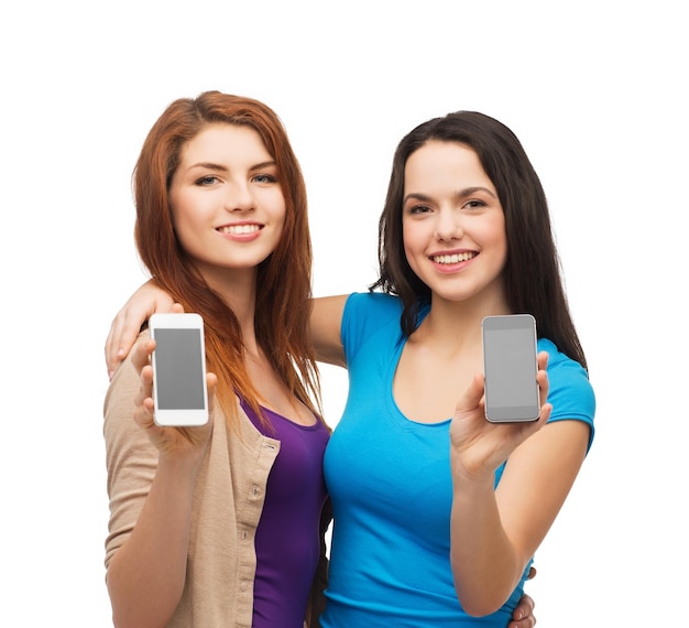 education and modern technology concept - smiling students showing blank smartphones screens