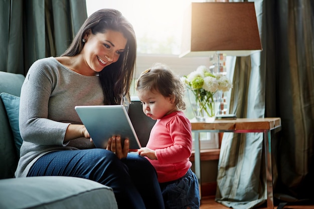 education mother and child with tablet in living room together for internet connection and development in home woman kid or daughter with tech on couch for online learning and studying with love