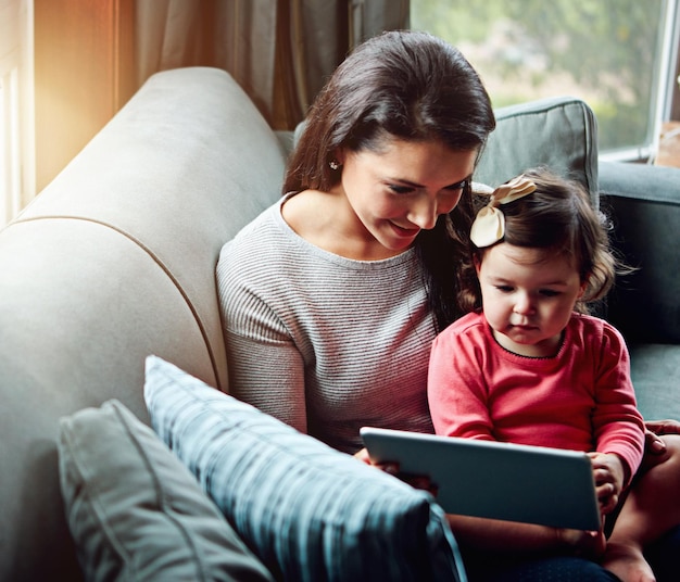 education mother and child with tablet on sofa together for internet connection and development in home woman kid or daughter with tech on couch for online learning and studying with love