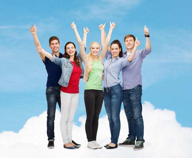 education and people concept - group of smiling students standing and showing thumbs up