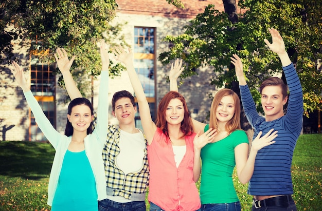 Education and people concept - group of smiling students standing and waving hands