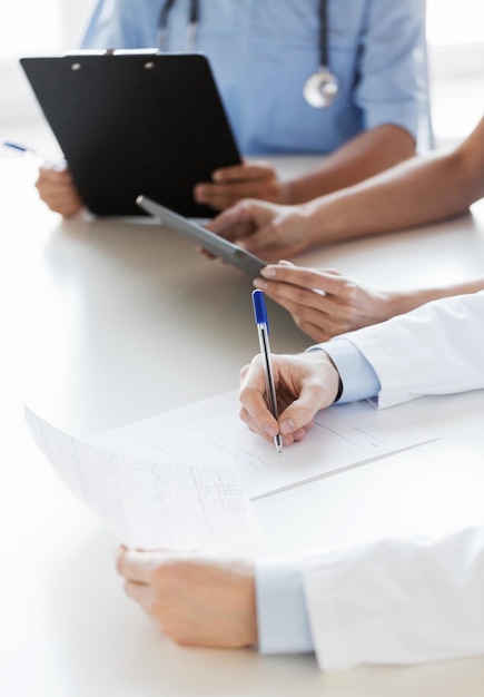 Foto concetto di istruzione, professione, persone e medicina - primo piano di medici felici con computer tablet pc e documenti al seminario o all'ospedale