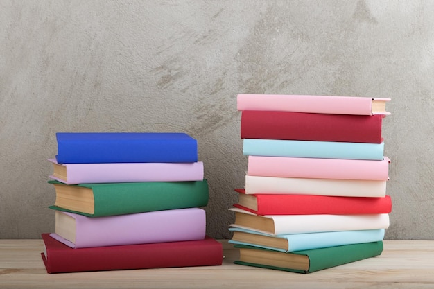 Education and reading concept group of colorful books on the wooden table concrete wall blackboard