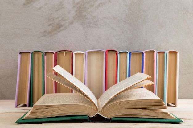 Концепция образования и чтения группа красочных книг на доске бетонной стены деревянного стола