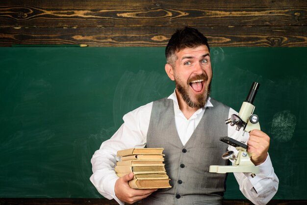 Education research knowledge technology happy male teacher holds books and microscope student doing