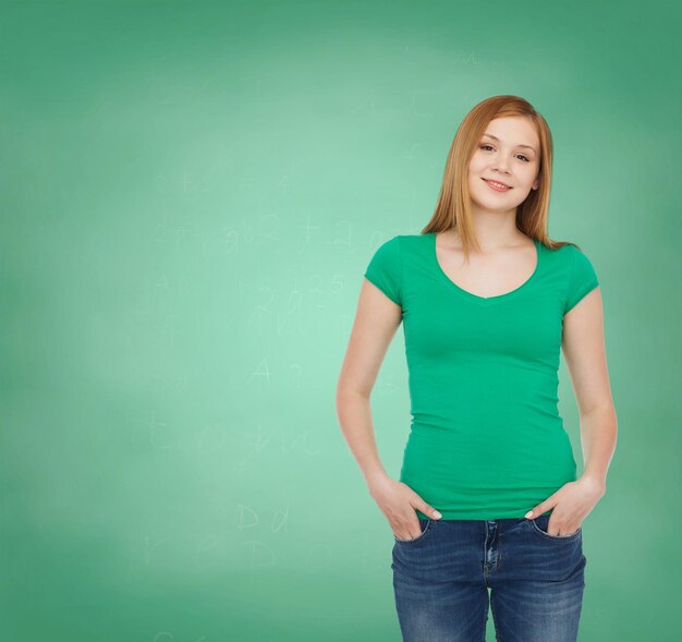 education, school, advertisement and people concept - smiling teenage girl in casual clothes over green board background