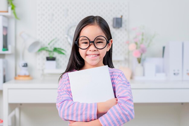 Education and school concept little student girl reading book