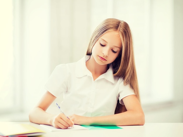 education and school concept - little student girl studying at school