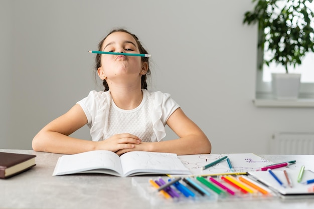 Photo education and school concept - smiling little student girl with many books at school.