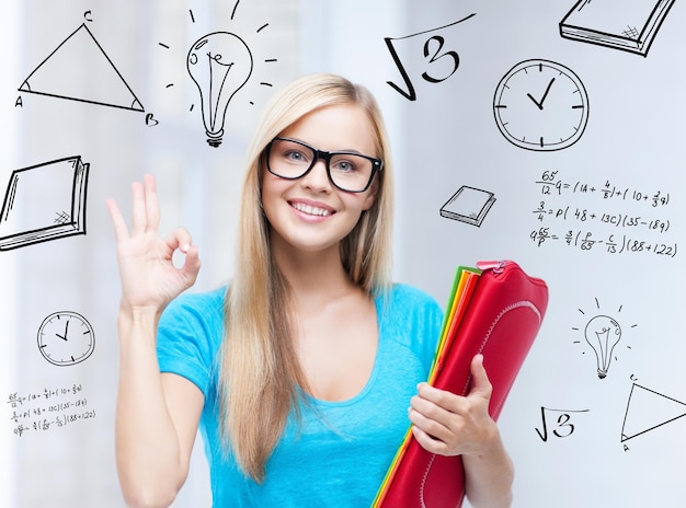 education and school concept - smiling student with folders showing ok sign