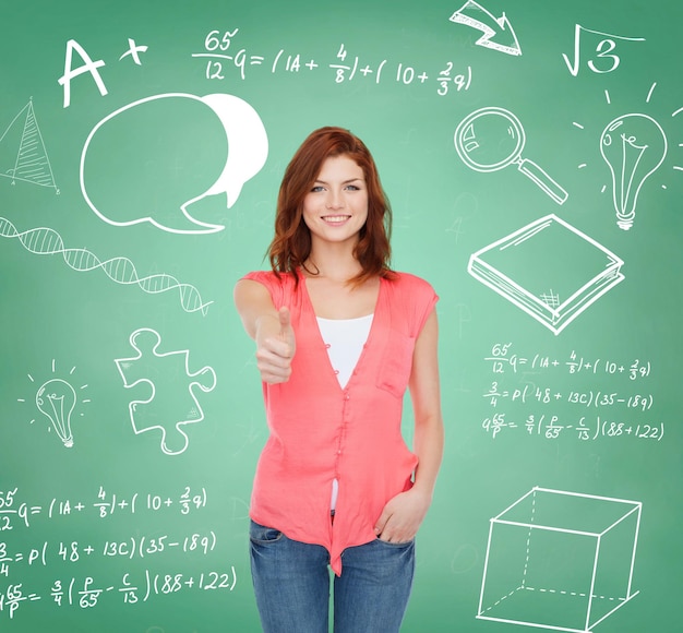 education, school, gesture and people concept - smiling teenage girl in casual clothes showing thumbs up over green board background