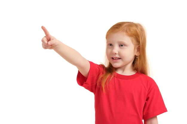 Концепция образования, школы и воображаемого экрана - милая маленькая девочка, указывающая в воздухе или воображаемый экран