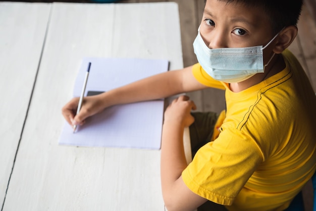 Education, school and pandemic concept - student boy wearing face protective medical mask