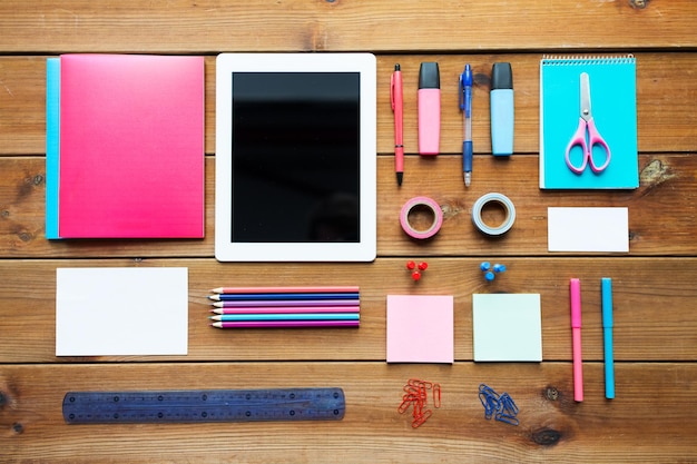 education, school supplies, art, creativity and object concept - close up of stationery and tablet pc computer on wooden table