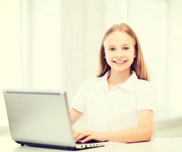 교육, 학교, 기술 및 인터넷 개념 - 학교에서 노트북 PC가 있는 어린 학생 소녀