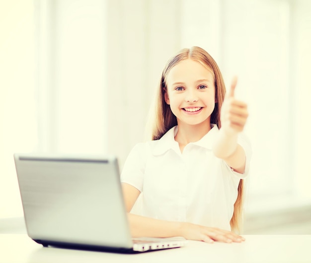 교육, 학교, 기술 및 인터넷 개념 - 학교에서 노트북 PC가 있는 어린 학생 소녀