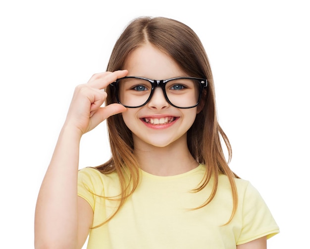 education, school and vision concept - smiling cute little girl in black eyeglasses