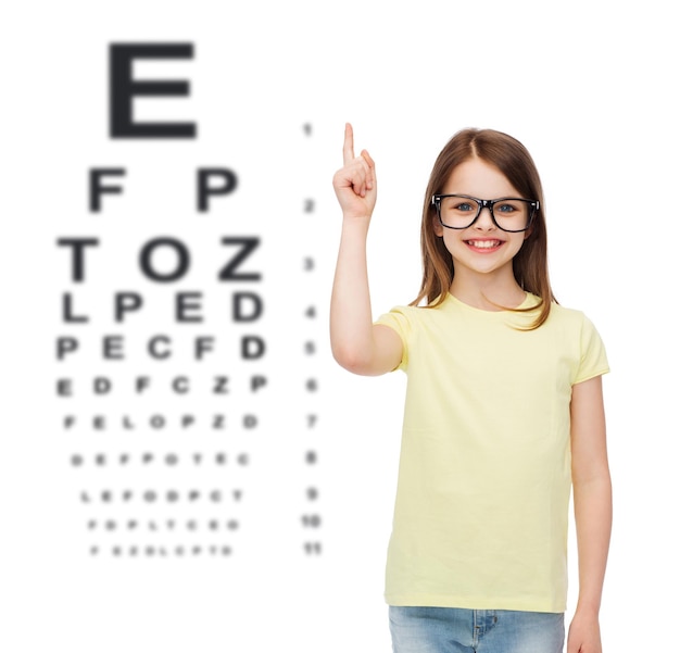 education, school and vision concept - smiling cute little girl in black eyeglasses