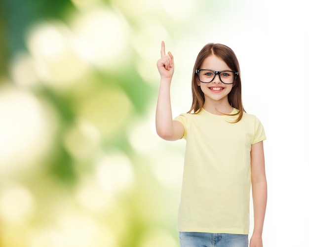 education, school and vision concept - smiling cute little girl in black eyeglasses