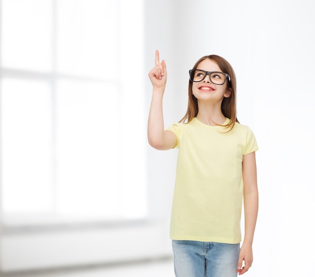 education, school and vision concept - smiling cute little girl in black eyeglasses