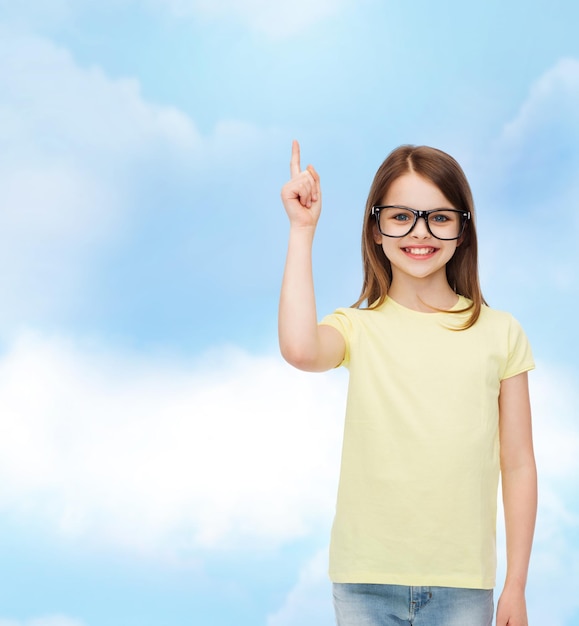 education, school and vision concept - smiling cute little girl in black eyeglasses