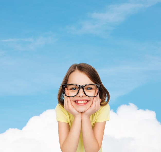 education, school and vision concept - smiling cute little girl in black eyeglasses