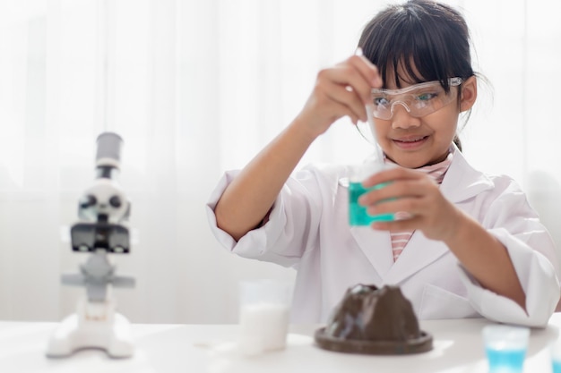 Education science chemistry and children concept kids or students with test tube making experiment at school laboratory