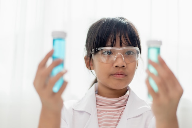 Education science chemistry and children concept kids or students with test tube making experiment at school laboratory