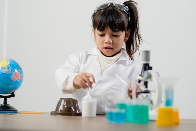 Education science chemistry and children concept kids or students with test tube making experiment at school laboratory