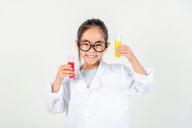 education science and children concept girl in goggles with magnifier studying test tube with chemi