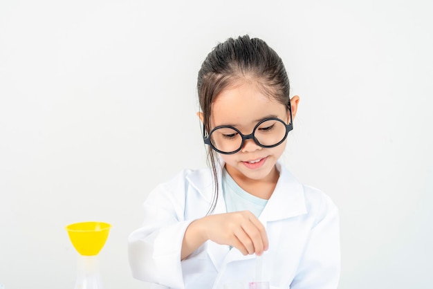 education science and children concept girl in goggles with magnifier studying test tube with chemi