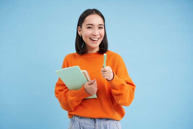 Education and students happy asian woman holding notebooks and laughing smiling at camera enjoys person