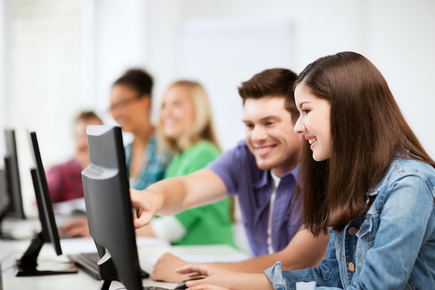 Educazione, tecnologia e internet - studenti con computer che studiano a scuola
